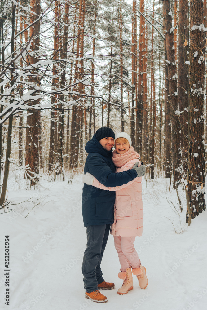 A loving couple walks in the woods. Family walk in the winter forest A loving couple walks in the woods. Family walk in the winter forest
