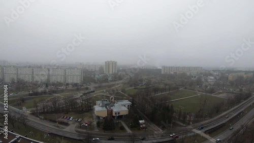 Foggy cityscape aerial view
Drone footage of a misty urban area with residential blocks, curving roads, and light traffic under overcast skies.