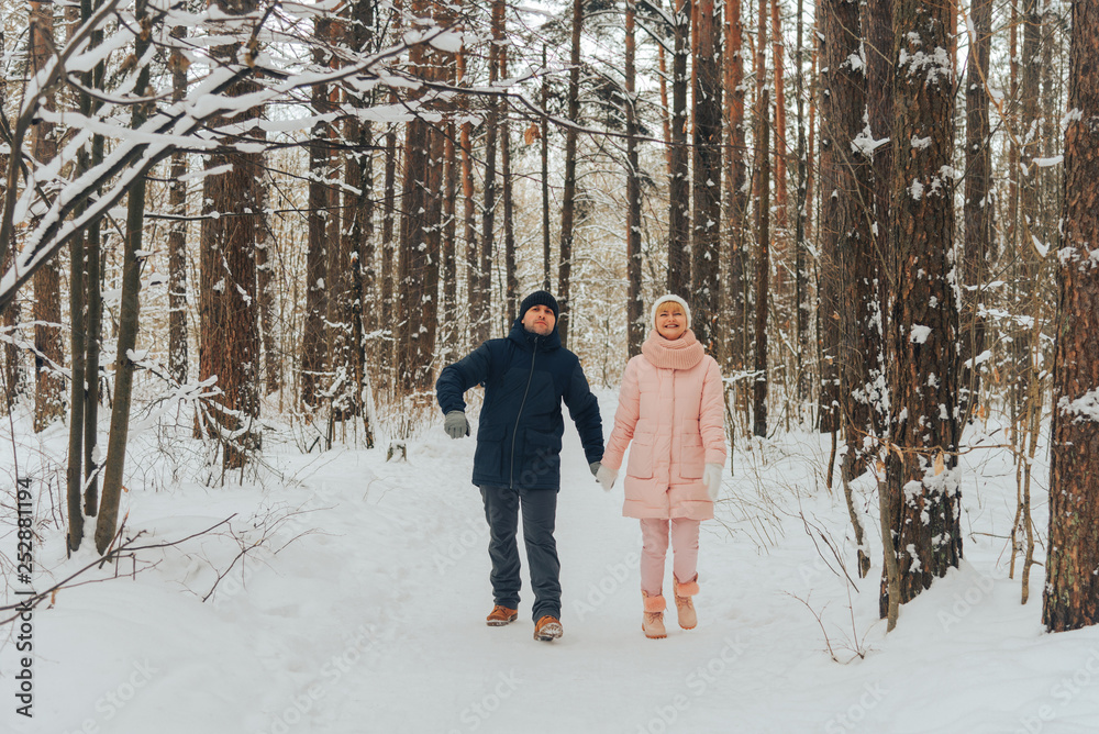 A loving couple walks in the woods. Family walk in the winter forest