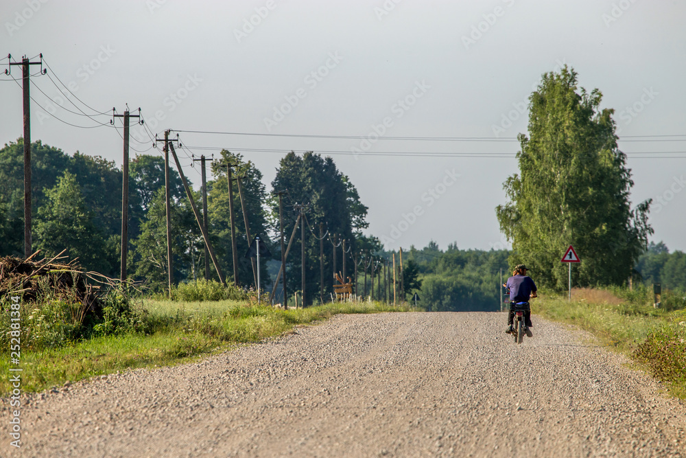 Landscape with rural road and man on moped.. Landscape with rural road and man on moped..