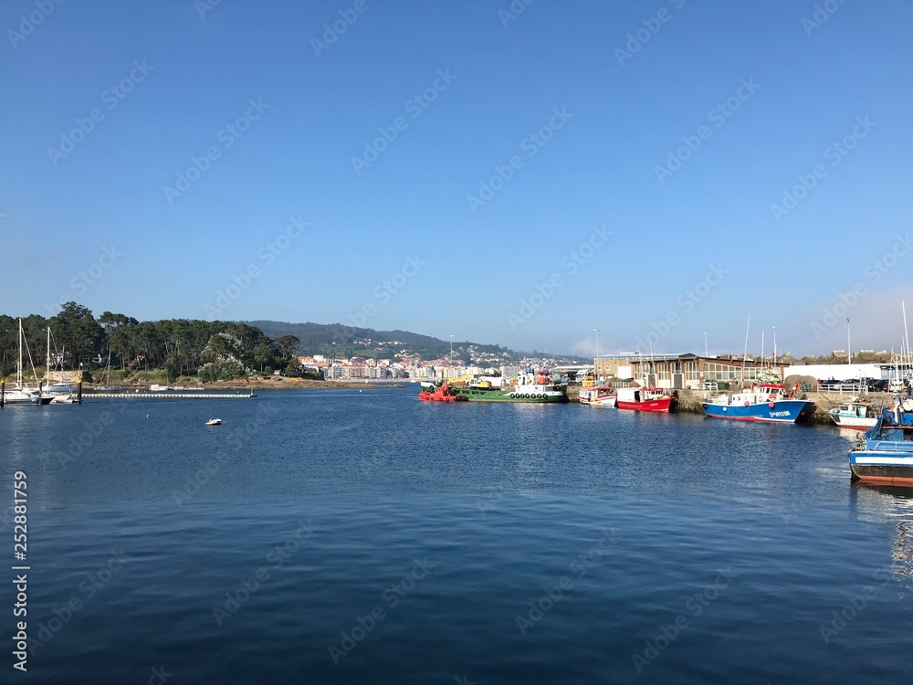 Some fishing boats docked at port during summer in Portonovo Spain