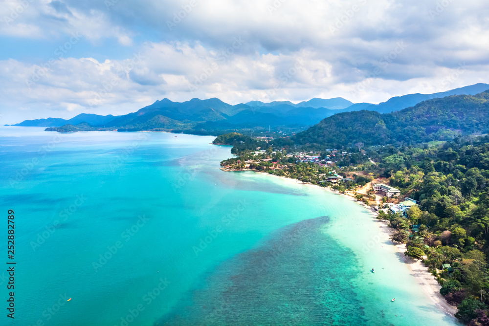 Aerial view of tropical island beach and coastline with transparent turquoise sea water and rainforest landscape, vacation holidays destination with touristic resorts
