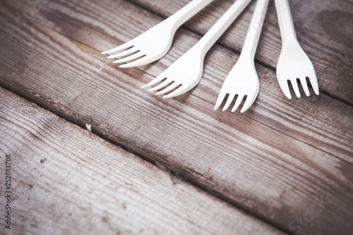 Plastic white forks on wooden background plastic free concept