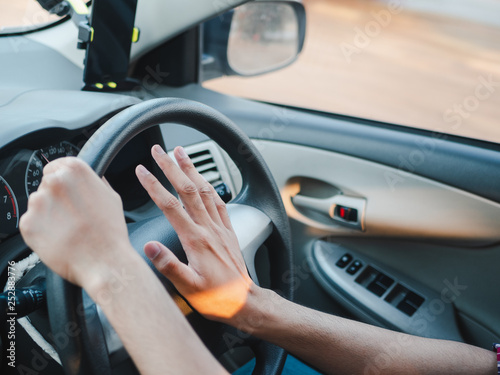 Bilde på lerret Closeup Driver's hand pressing on a car horn while driving