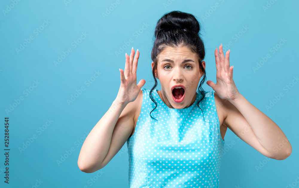 Young woman feeling stressed on a solid background