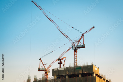 Working canes on top of construction site in the center of bangkok, Thailand with evening blue sky backgrounds.