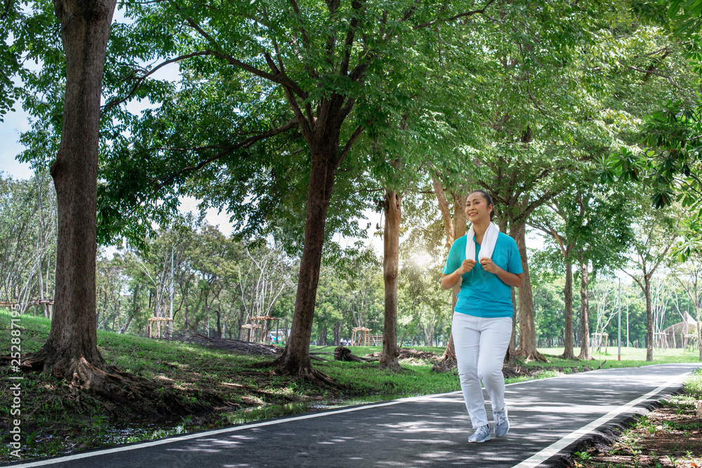Senior Asian sport woman jogging in the Jogging track, feel happy and smiling, elderly health care Senior Asian sport woman jogging in the Jogging track, feel happy and smiling, elderly health care