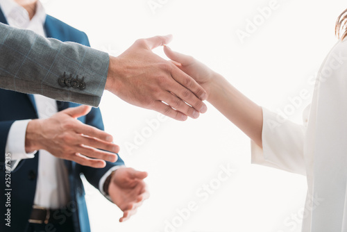 selective focus of men and woman shaking hands at office