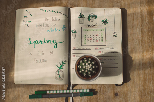 Spring quote on a journal notebook. Lettering example and sketching draws. Cactus