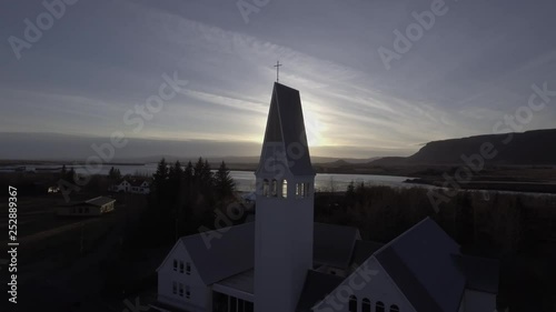 Aerial shot of Icelandic church near the river on sunset 4K