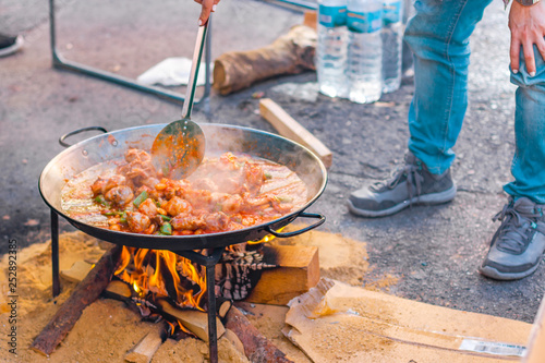 Paella preparation  on the street during fallas festivity. Valencian chicken paella.