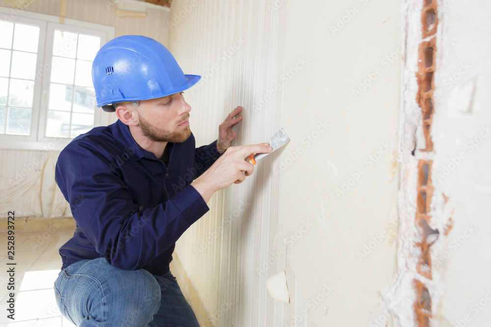 male plasterer in uniform polishing the wall male plasterer in uniform polishing the wall