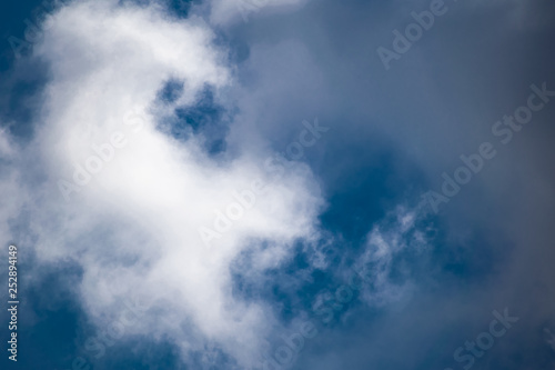 Simple winter blue sky with clouds and without, flying through the air. Natural primitive background, enlarged.