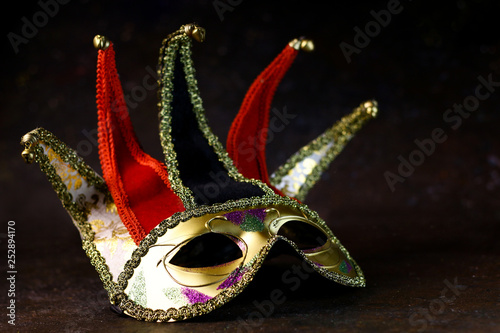 Carnival venetian Joker mask on dark background. Carnival mask side view.