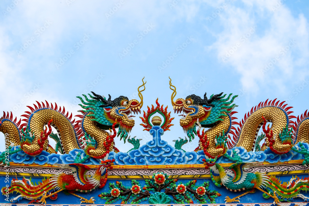 double dragon on roof of chinese temple gate and blue cloud
