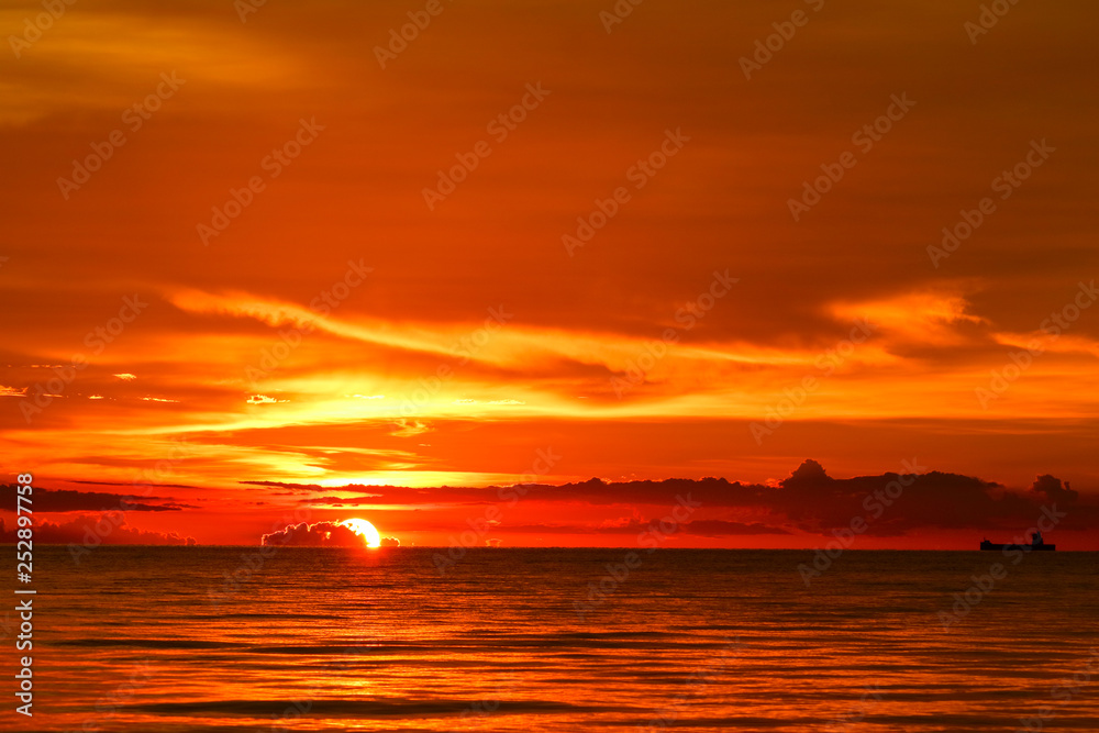 Fototapeta premium sunset on sea and ocean last light red sky silhouette cloud