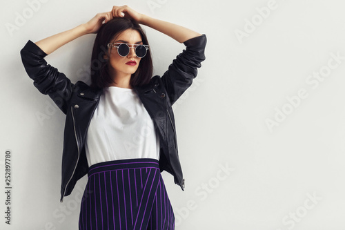 Young beautiful woman in a black jacket and sunglasses