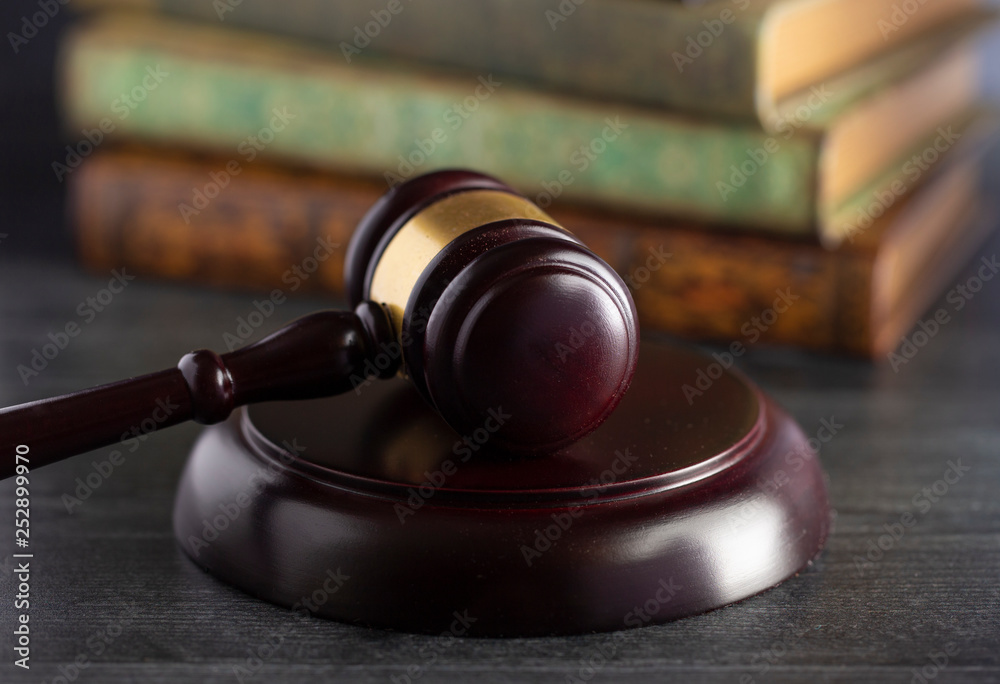 Obraz premium Judges Gavel on a Desk with Books in the Background