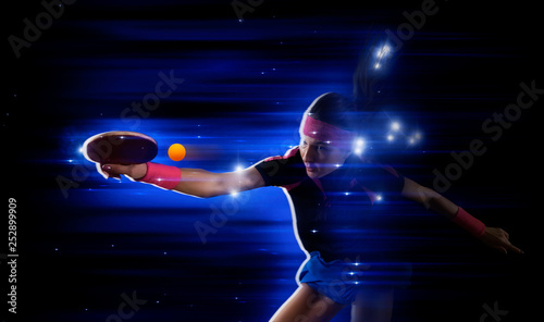 Portrait woman playing ping pong on dark blue