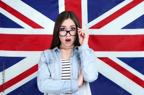 Young beautiful girl with black glasses on British flag background