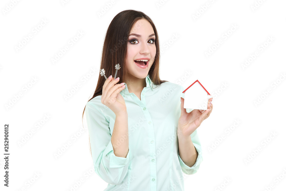 Young woman showing keys and wooden house on white background Young woman showing keys and wooden house on white background