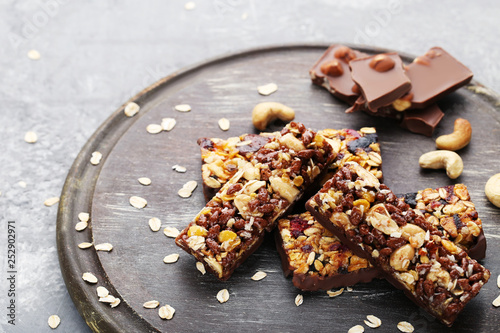 Granola bars with cashew and chocolate pieces on cutting board