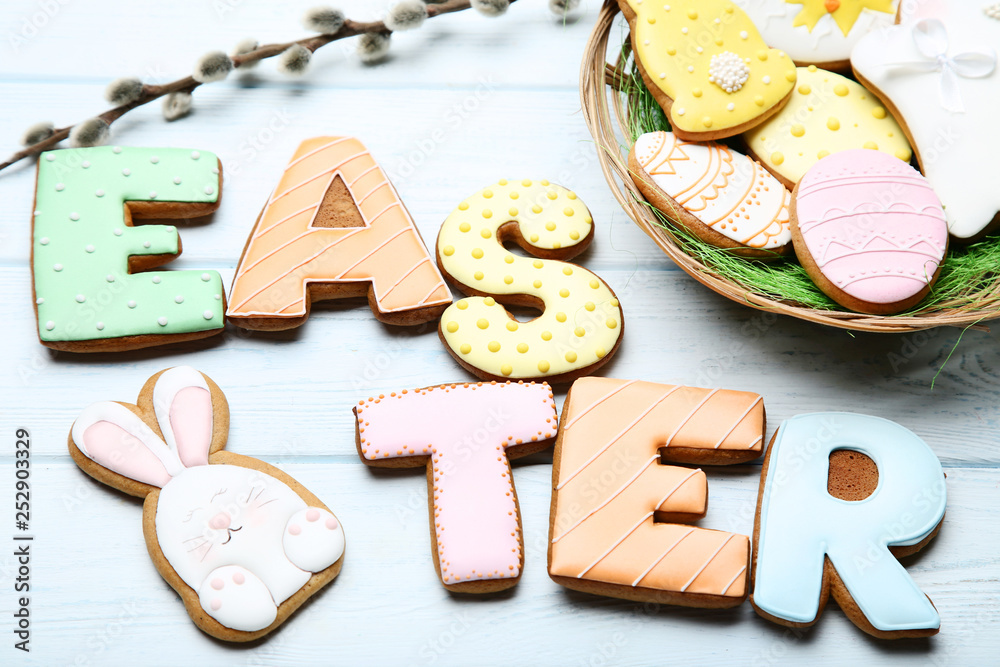 Easter gingerbread cookies with willow branch on wooden table