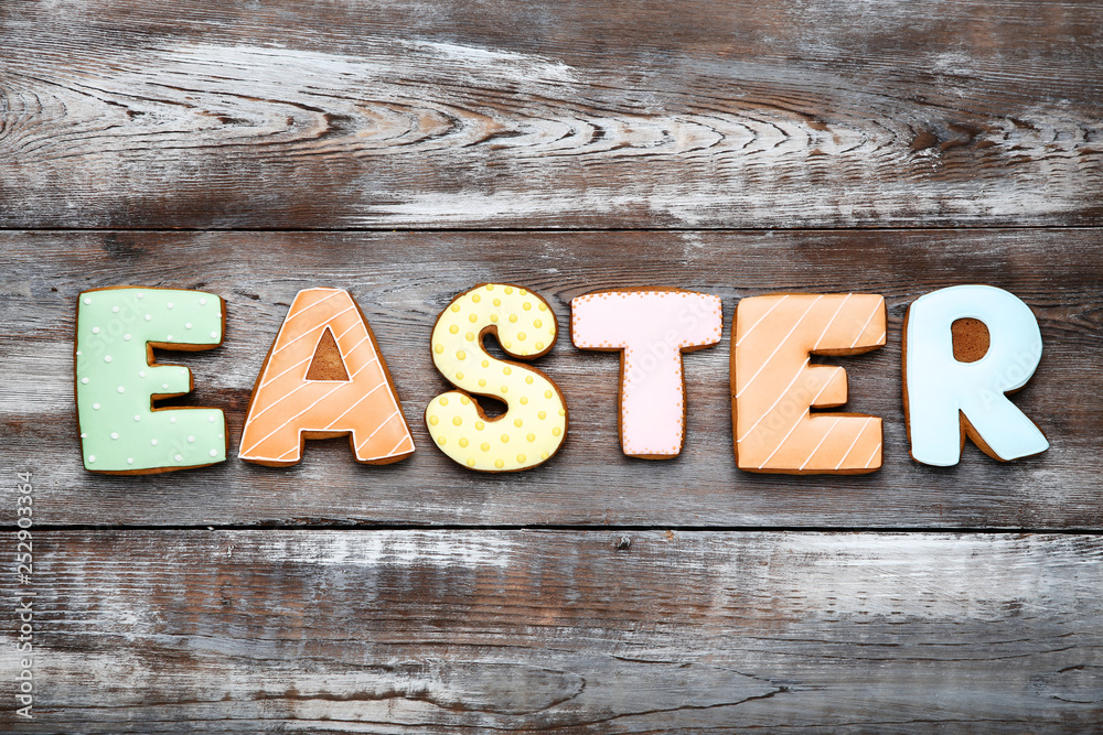 Fototapeta premium Word Easter gingerbread cookies on brown wooden table