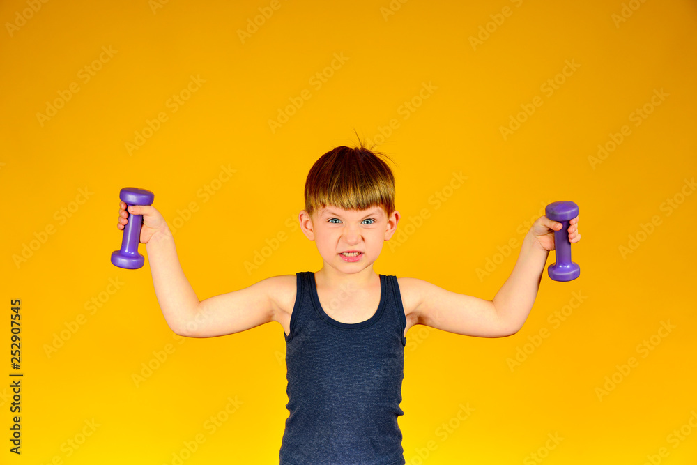 Mahi to the sides with dumbbells boy on a yellow background Mahi to the sides with dumbbells boy on a yellow background