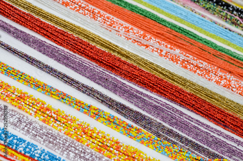 Background of colourful parallel lines of sand beards displayed on a white wooden table