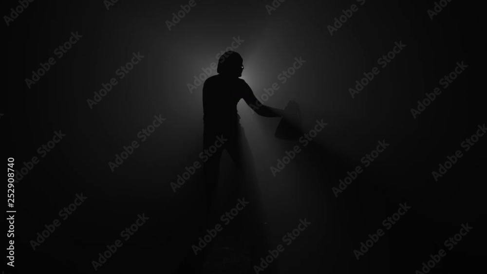 Silhouette of burglar with flashlight and bag Silhouette of burglar with flashlight and bag