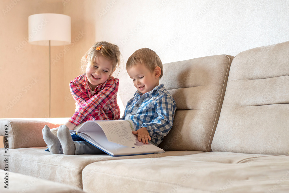 Cute little brother and sister reading book together at home Cute little brother and sister reading book together at home