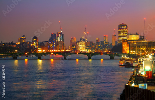 Westminster bridge illuminated in evening lights and the city of London in England, UK