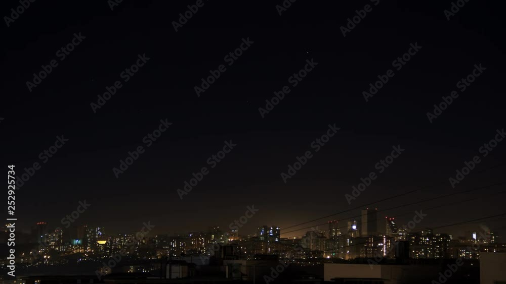 Night city skyline timelapse. Top aerial panoramic view of modern city from tower rooftop. Lights flicker in windows. Stars move on the dark sky. Night city skyline timelapse. Top aerial panoramic view of modern city from tower rooftop. Lights flicker in windows. Stars move on the dark sky.
