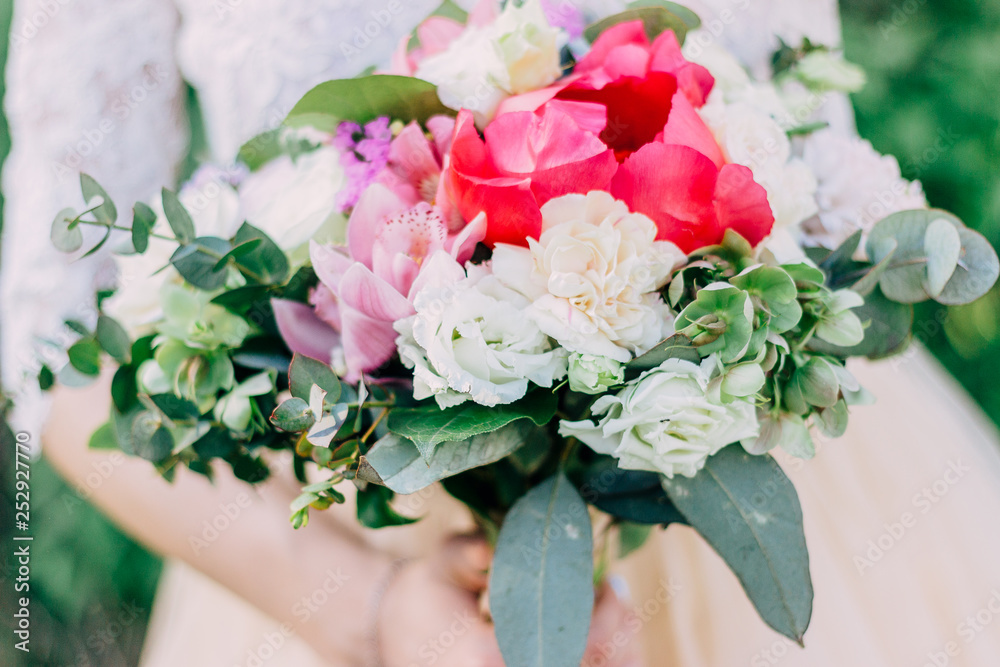 The bride holds a beautiful wedding bouquet of pink and white flowers in her hands The bride holds a beautiful wedding bouquet of pink and white flowers in her hands