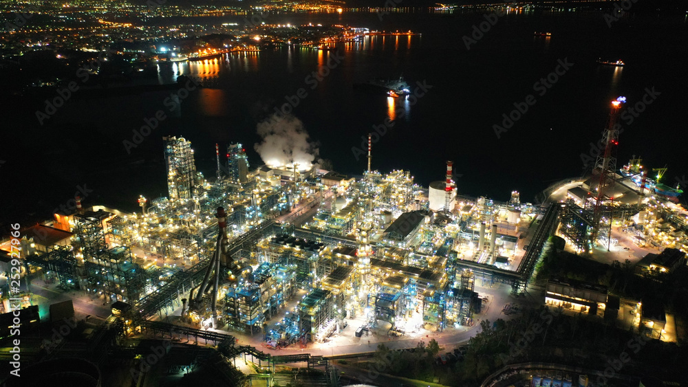 Fototapeta premium Aerial drone night shot of petrochemical industrial complex with oil refinery in area of Elefsina, Attica, Greece