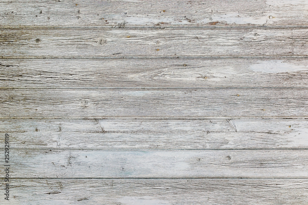 Aged surface of horizontal wooden planks with cracked white paint. Peeling paint on an old wooden wall. Aged surface of horizontal wooden planks with cracked white paint. Peeling paint on an old wooden wall.