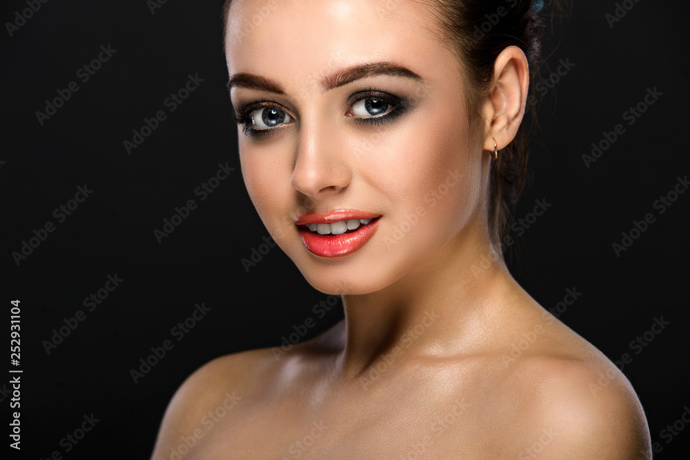Portrait of a beautiful young girl with a clean face. A girl with a dark make-up on a dark background. Smiles Portrait of a beautiful young girl with a clean face. A girl with a dark make-up on a dark background. Smiles