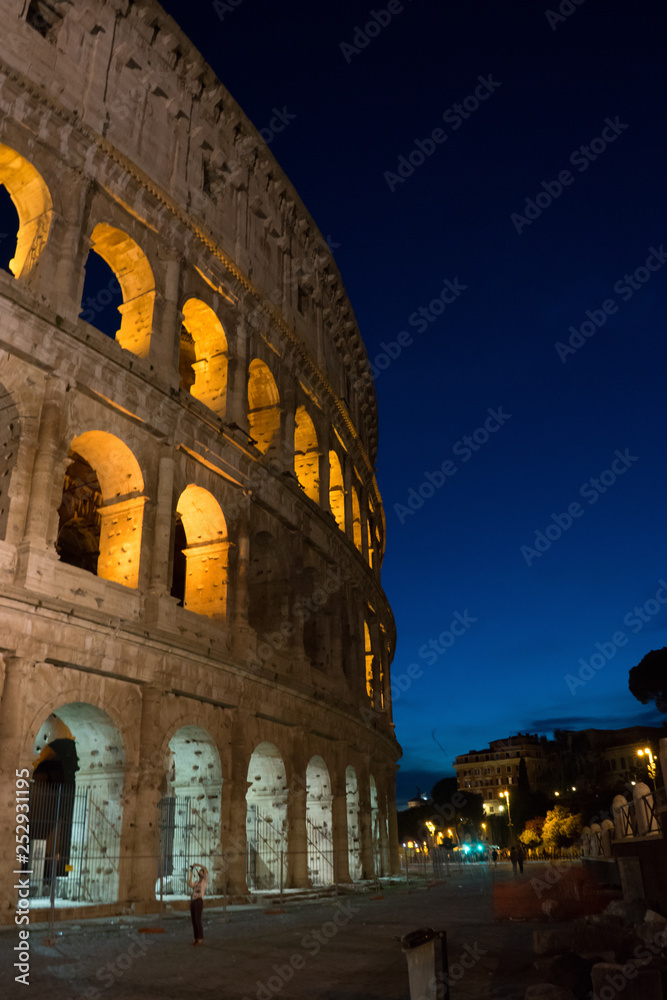 Naklejka premium Night at the Great Roman Colosseum (Coliseum, Colosseo), also known as the Flavian Amphitheatre with lights & illumination.