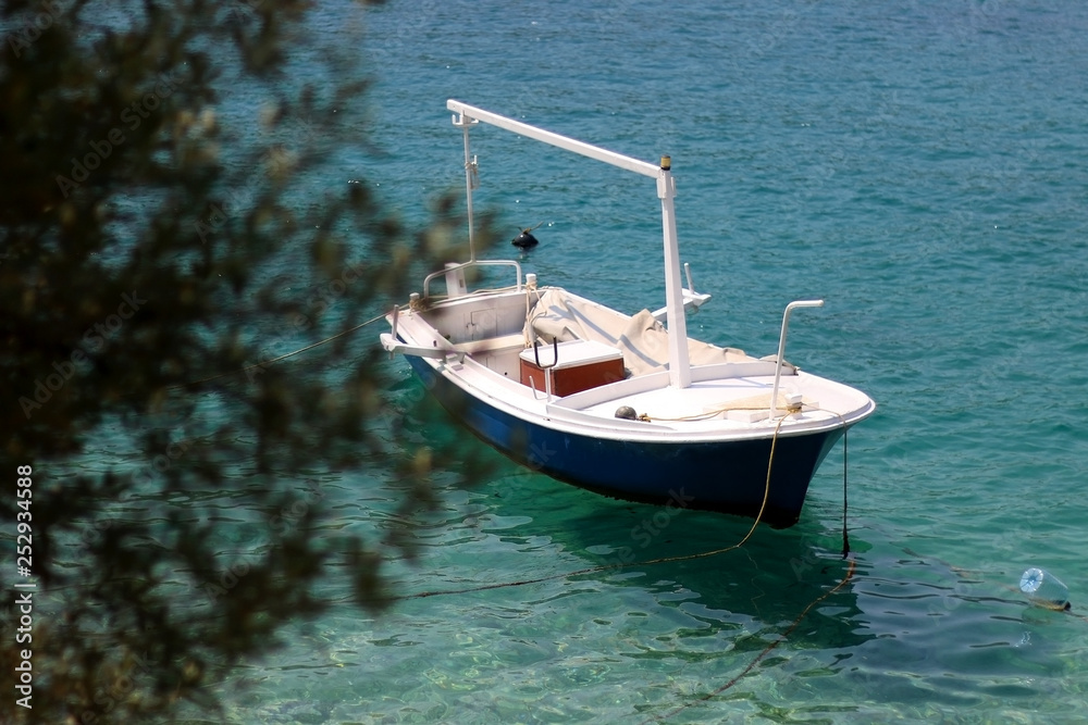 Fototapeta premium Small boat and olive tree in Vela Luka, island Korcula, Croatia. Selective focus.