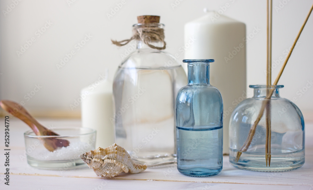 Natural organic cosmetics in glass bottles, near candles, sea salt and incense sticks. Spa skin care, home spa. Bottles with lotion on wooden background. Natural organic cosmetics in glass bottles, near candles, sea salt and incense sticks. Spa skin care, home spa. Bottles with lotion on wooden background.