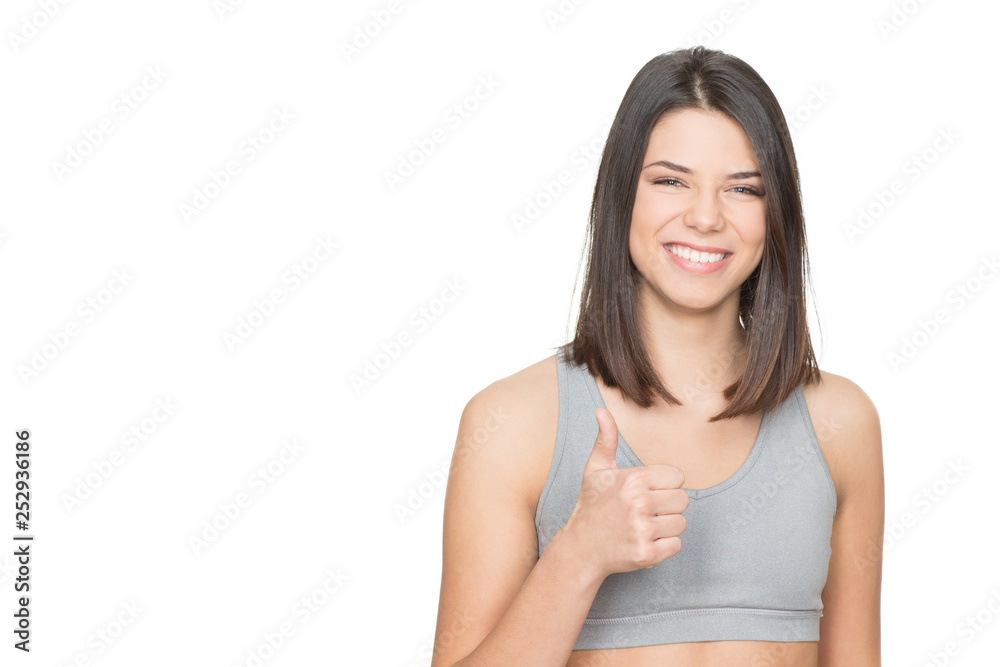 Happy and healthy. Portrait of an attractive female in sports clothing showing thumbs up isolated on white Happy and healthy. Portrait of an attractive female in sports clothing showing thumbs up isolated on white
