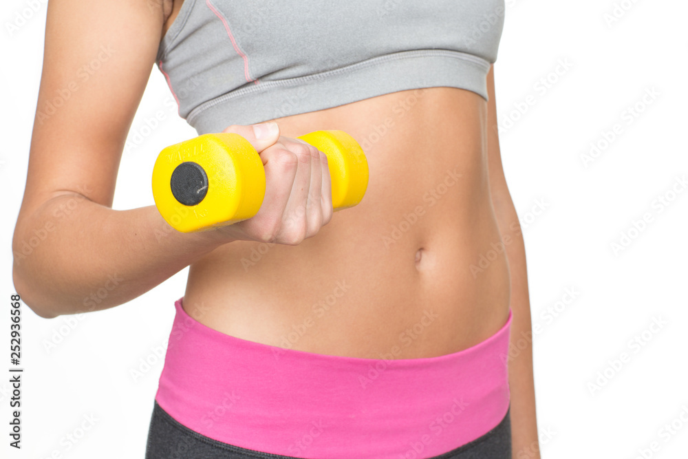 Getting in shape. Cropped closeup of a female with flat stomach posing with a dumbbell in her hand isolated on white Getting in shape. Cropped closeup of a female with flat stomach posing with a dumbbell in her hand isolated on white