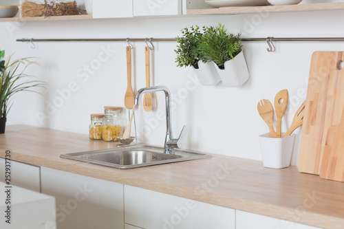 White kitchen Interior in scandinavian style with kitchenware and green plants photo