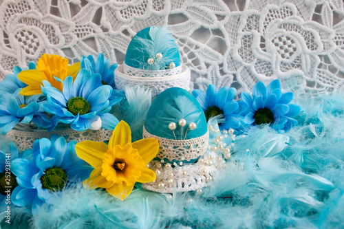  Easter composition with blue eggs, yellow and blu spring flowers and white lace