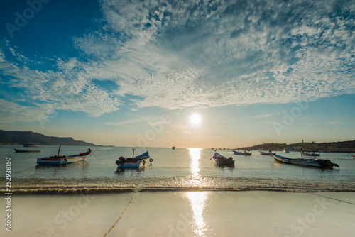 Boats anchored during a dramatic and beautiful sunset in Juan Griego beach, Margarita Island, Venezuela