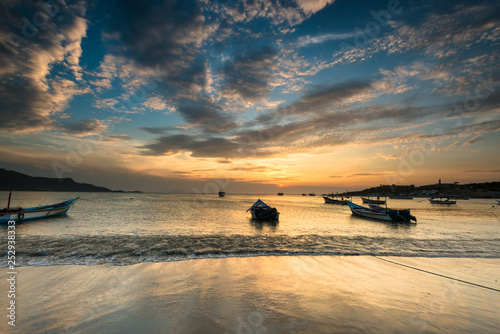 Boats anchored during a dramatic and beautiful sunset in Juan Griego beach, Margarita Island, Venezuela photo