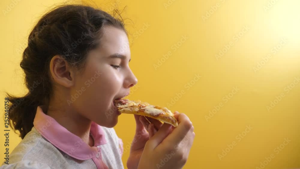 happy little girl eating a slice of pizza concept. teenager child hungry eats a lifestyle slice of pizza. slow motion video. pizza fast food concept happy little girl eating a slice of pizza concept. teenager child hungry eats a lifestyle slice of pizza. slow motion video. pizza fast food concept