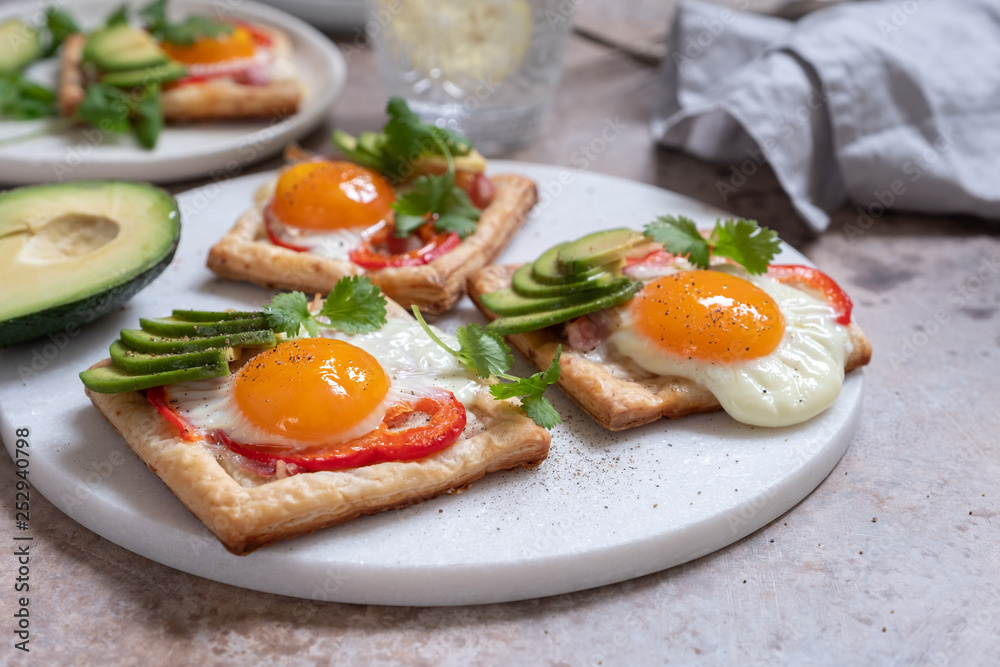 Baked puff pastry with fried egg, pepper and avocado