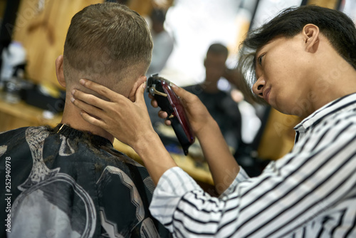 Man is cutting his hair in asian barbershop